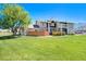 Exterior shot of the house with green grass and a big tree on a sunny day at 6962 W 87Th Way # 270, Arvada, CO 80003