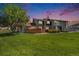 Exterior shot of the house with green grass and a big tree on a beautiful sky at dusk at 6962 W 87Th Way # 270, Arvada, CO 80003