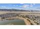 An extensive aerial view showing a neighborhood with a pond surrounded by native grasses and mountain views at 9896 W Freiburg Dr # 1B, Littleton, CO 80127