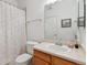 Bright bathroom showcasing a single sink vanity, a toilet, and a shower tub with a decorative curtain at 9896 W Freiburg Dr # 1B, Littleton, CO 80127