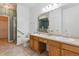 Bright bathroom with dual sinks, tile flooring, and a step-in shower with a grab bar at 9896 W Freiburg Dr # 1B, Littleton, CO 80127