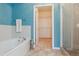Bright bathroom featuring a soaking tub, a separate shower and a linen closet at 9896 W Freiburg Dr # 1B, Littleton, CO 80127
