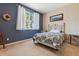 Bedroom featuring blue accent wall with a decorative wreath and a metal bed frame at 9896 W Freiburg Dr # 1B, Littleton, CO 80127