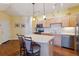 Bright kitchen with stainless steel appliances, wood cabinets, tile backsplash, and a convenient breakfast bar at 9896 W Freiburg Dr # 1B, Littleton, CO 80127