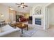 Open-concept living area featuring a fireplace, neutral interior, and transition to a dining and kitchen area at 9896 W Freiburg Dr # 1B, Littleton, CO 80127