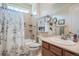 Traditional bathroom has a combination tub and shower, a mirrored vanity, and a large window at 14883 Roslyn Way, Thornton, CO 80602