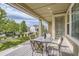 Inviting covered patio with outdoor dining set, perfect for al fresco meals and enjoying the serene backyard view at 14883 Roslyn Way, Thornton, CO 80602