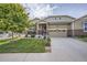 Charming two-story home featuring a well-manicured lawn and inviting front porch with decorative brick accents at 14883 Roslyn Way, Thornton, CO 80602