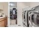 Laundry room features a large washer and dryer, with a walk in closet visible through the doorway at 14883 Roslyn Way, Thornton, CO 80602