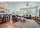 Bright living room featuring hardwood floors, large windows, and comfortable seating arrangement with natural light at 14883 Roslyn Way, Thornton, CO 80602