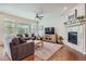 Cozy living room with a fireplace, hardwood floors, comfortable sofas, and a ceiling fan at 14883 Roslyn Way, Thornton, CO 80602