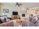 Inviting living room with a fireplace, hardwood floors, comfortable seating, and a ceiling fan at 14883 Roslyn Way, Thornton, CO 80602