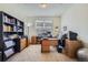 Organized home office featuring a large window, built-in shelves, and multiple work stations at 14883 Roslyn Way, Thornton, CO 80602