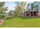 Sprawling backyard featuring lush lawn, mature trees, a fire pit and a deck with stairs, perfect for outdoor living at 23427 Song Bird Hills Pl, Parker, CO 80138