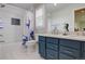 Well-lit bathroom featuring a tub/shower combo and a blue vanity with dual sinks and modern fixtures at 23427 Song Bird Hills Pl, Parker, CO 80138