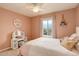 Light-filled pink bedroom featuring a makeup vanity, a decorative wall hanging, and a window view at 23427 Song Bird Hills Pl, Parker, CO 80138