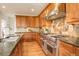 Gourmet kitchen with stainless steel appliances, granite countertops, and custom cabinetry at 23427 Song Bird Hills Pl, Parker, CO 80138