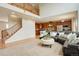 Open-concept living room featuring a staircase, kitchen, and comfortable seating on plush carpet at 23427 Song Bird Hills Pl, Parker, CO 80138