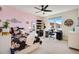 Bright bedroom with pink accent wall, ceiling fan, desk and large window at 3210 Mallard Creek Rd, Berthoud, CO 80513