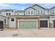 Townhome exterior featuring stone accents and a two-car garage at 14284 W 88Th Dr # B, Arvada, CO 80005