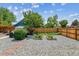 Landscaped backyard with pergola, gravel, garden beds, and wooden fence at 2196 W 56Th Ave, Denver, CO 80221