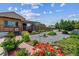 Landscaped front yard showcasing colorful flowers, rock beds, a brick walkway and a covered porch at 2196 W 56Th Ave, Denver, CO 80221