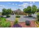Landscaped front yard with decorative rock, mulch beds, flowering plants, and mature trees at 2196 W 56Th Ave, Denver, CO 80221