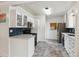 An efficient kitchen featuring white cabinets, a microwave, and a stylish blue backsplash at 2196 W 56Th Ave, Denver, CO 80221