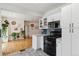 Well-lit kitchen boasts white cabinets, black appliances, and an open layout at 2196 W 56Th Ave, Denver, CO 80221