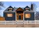 Front exterior of a blue two-story house with a wood-covered entrance and white picket fence at 285 E Dartmouth Ave, Englewood, CO 80113