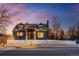 Inviting blue two-story home with a classic white picket fence and beautiful dusk sky backdrop at 285 E Dartmouth Ave, Englewood, CO 80113