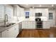 Bright white kitchen features stainless steel appliances, stylish subway tile backsplash, and hardwood floors at 285 E Dartmouth Ave, Englewood, CO 80113