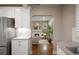 Modern kitchen featuring stainless steel appliances and white cabinets, leading to a cozy living area at 285 E Dartmouth Ave, Englewood, CO 80113