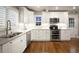 Modern kitchen with white cabinets, stainless steel appliances, and hardwood floors at 285 E Dartmouth Ave, Englewood, CO 80113