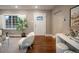 Bright living room with hardwood floors, a front door with glass, and a large window with shutters at 285 E Dartmouth Ave, Englewood, CO 80113