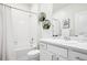 Clean bathroom featuring a shower and tub combo, white tile, and modern vanity at 7414 E 158Th Pl, Thornton, CO 80602