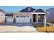 Inviting two-story home featuring stone accents, a spacious two-car garage, and a welcoming front porch at 7414 E 158Th Pl, Thornton, CO 80602