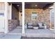 Comfortable front porch with stylish seating, stone accents, and a welcoming ambiance at 7414 E 158Th Pl, Thornton, CO 80602