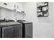 Modern laundry room featuring newer washer and dryer units and shelving for storage at 7414 E 158Th Pl, Thornton, CO 80602