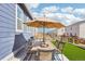 Outdoor patio featuring an outdoor dining area with an umbrella and artificial grass at 7414 E 158Th Pl, Thornton, CO 80602