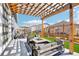 Outdoor patio featuring modern seating, a pergola, and artificial grass at 7414 E 158Th Pl, Thornton, CO 80602