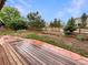 A beautiful backyard with a wood fence, deck, landscape, and partial garden area at 584 W Prestwick Way, Castle Rock, CO 80104