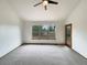 Bright bedroom with neutral carpet, a ceiling fan, and a large window offering outdoor views at 584 W Prestwick Way, Castle Rock, CO 80104