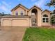 Two-story house showcasing attached two car garage, arched entry, and well-manicured front yard at 584 W Prestwick Way, Castle Rock, CO 80104