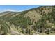 Scenic aerial view of a home nestled among lush green trees on a hillside at 11080 S Deer Creek Rd, Littleton, CO 80127
