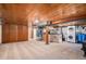 Open basement area featuring a kitchenette, laundry area, and storage with carpeted floors at 11080 S Deer Creek Rd, Littleton, CO 80127