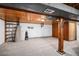 Spacious basement area featuring carpeted floors, wood beams and column, and ample storage space at 11080 S Deer Creek Rd, Littleton, CO 80127