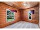 Charming bedroom featuring wood-paneled walls and ceilings, with natural light streaming through the windows at 11080 S Deer Creek Rd, Littleton, CO 80127