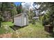 Exterior shot of an outbuilding on grassy yard and brick oven, surrounded by trees at 11080 S Deer Creek Rd, Littleton, CO 80127