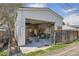 Garage exterior with open door, wooden privacy fence and greenery at 3064 S Cherokee St, Englewood, CO 80110